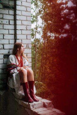 Ukrayna 'daki savaşın teması üzerine sanat çalışmaları. Ukraynalı hayal kırıklığına uğramış bir kadın, Rus ordusu tarafından bombalanan binanın penceresinde oturuyor..