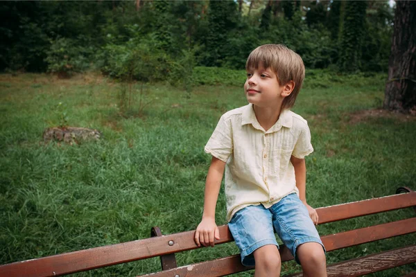 Portrait Little Cute Smiling Boy Denim Shorts Yellow Shirt Sits — Zdjęcie stockowe