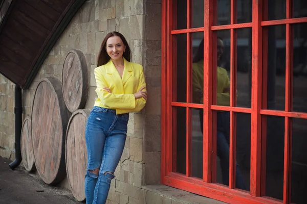 Stylowa Szczupła Uśmiechnięta Kobieta Stoi Pobliżu Budynku Drewnianymi Czerwonymi Oknami — Zdjęcie stockowe