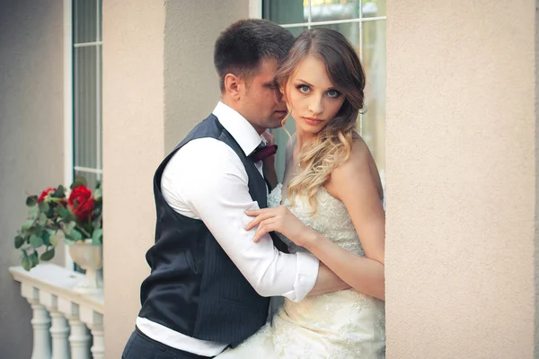 Sanat eserleri. Yeni evliler şık bir şekilde restoranın arka planına sarılıyorlar. Gelin hafif bir gelinlik giyiyor, damat beyaz gömlek, kazak ve papyon giyiyor..