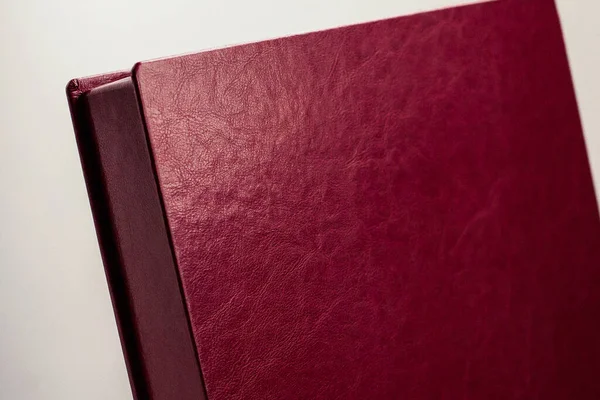 Burgundy leather box for a photo book on a light background.