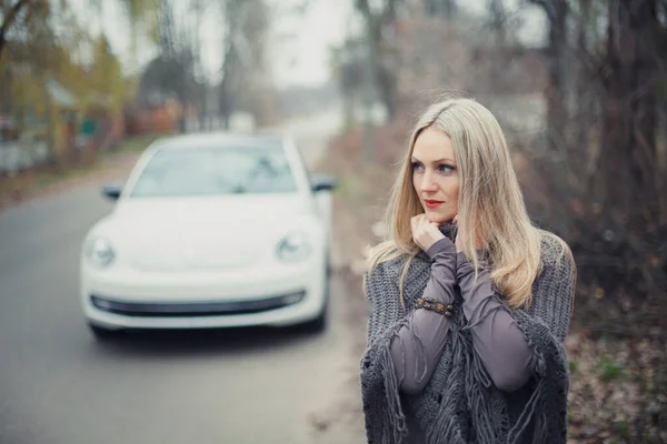 금발의 아름다운 소녀가 구름낀 자동차 사진입니다 — 스톡 사진