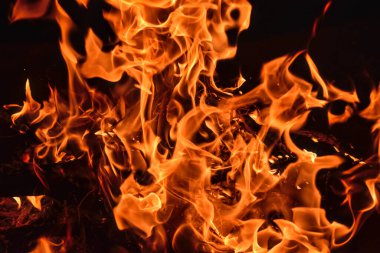 Bir yangın kasesinde kırmızı alevlerin yakın çekimi