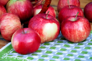 Tahta bir masada sepetteki kırmızı elmalar..