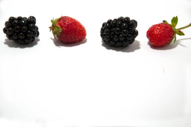 Böğürtlenler ve çilekler tek sıra halinde uzanır.