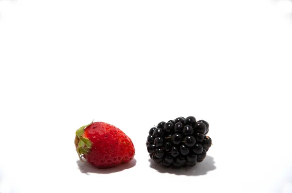 Una mora y una fresa sobre un fondo blanco. — Foto de Stock