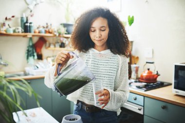 Genç Afrikalı kız sağlıklı içeceğini hazırlıyor.