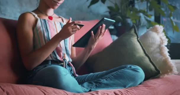 自宅のソファでリラックスしながらメモを作る若い女性のショット 高品質4K映像 — ストック動画
