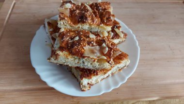 Doğulu cheesecake. Süt Hamuru tabağı. Reçelle yenebilir. Yemekler beyaz tabakta yakın plan. Hasır örülmüş arka plan. Retro tarzı. Ev ortamı. Kırsal alan. Tuzlu Peynirli Pasta. Görünüm.