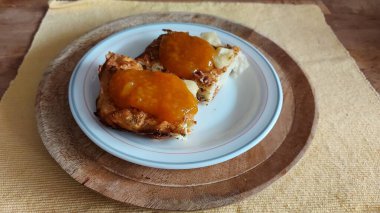 Doğulu cheesecake. Süt Hamuru tabağı. Reçelle yenebilir. Yemekler beyaz tabakta yakın plan. Hasır örülmüş arka plan. Retro tarzı. Ev ortamı. Kırsal alan. Tuzlu Peynirli Pasta. Görünüm.