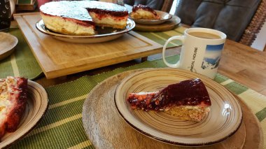 Cheesecake lezzetli bir meyve tatlısıdır. Dolgusu süzme peynir ya da mascarpone ile geliyor. Üstünde kırmızı böğürtlen reçeli var. Kırmızı tatlı reçel üstte. Meyveli kek tabakta. Yemek yakın planda..