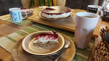 Cheesecake lezzetli bir meyve tatlısıdır. Dolgusu süzme peynir ya da mascarpone ile geliyor. Üstünde kırmızı böğürtlen reçeli var. Kırmızı tatlı reçel üstte. Meyveli kek tabakta. Yemek yakın planda..