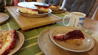 Cheesecake lezzetli bir meyve tatlısıdır. Dolgusu süzme peynir ya da mascarpone ile geliyor. Üstünde kırmızı böğürtlen reçeli var. Kırmızı tatlı reçel üstte. Meyveli kek tabakta. Yemek yakın planda..