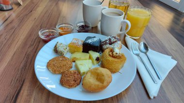 Ahşap arka planda kahve ve kek. Beyaz peçete. Kanabec keki. Ananas dilimleri. Meyve reçelli cam kaseler. Şeker şurubu tatlısı. Kalorili kekler. Doğulu tatlılar.