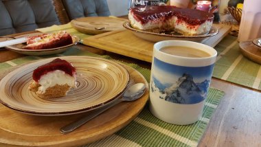 Cheesecake lezzetli bir meyve tatlısıdır. Dolgusu süzme peynir ya da mascarpone ile geliyor. Üstünde kırmızı böğürtlen reçeli var. Kırmızı tatlı reçel üstte. Meyveli kek tabakta. Yemek yakın planda..