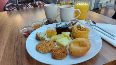Çörekler. Susamlı kek. Meyve reçelli kavanozlar. Portakal suyu ve kahve. Beyaz porselen tabakta tatlılar. Doğulu kurabiyeler. Restoran sahnesi. Şeker şurubu tatlısı. Kalorili kekler. Resmi kapat.. 