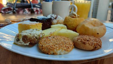 Çörekler. Susamlı kek. Meyve reçelli kavanozlar. Portakal suyu ve kahve. Beyaz porselen tabakta tatlılar. Doğulu kurabiyeler. Restoran sahnesi. Şeker şurubu tatlısı. Kalorili kekler. Resmi kapat.. 