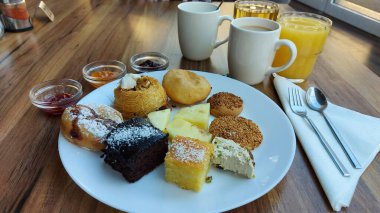 Çörekler. Susamlı kek. Meyve reçelli kavanozlar. Portakal suyu ve kahve. Beyaz porselen tabakta tatlılar. Doğulu kurabiyeler. Restoran sahnesi. Şeker şurubu tatlısı. Kalorili kekler. Resmi kapat.. 