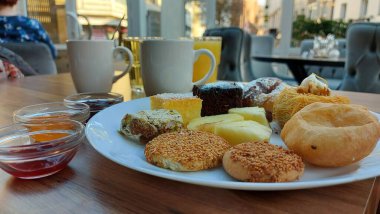 Çörekler. Susamlı kek. Meyve reçelli kavanozlar. Portakal suyu ve kahve. Beyaz porselen tabakta tatlılar. Doğulu kurabiyeler. Restoran sahnesi. Şeker şurubu tatlısı. Kalorili kekler. Resmi kapat.. 