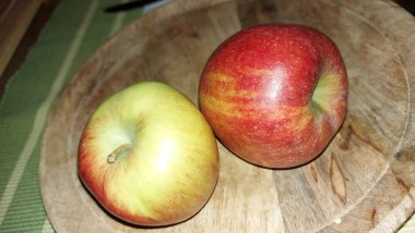 Ahşap servis tabağında elmalar. Organik meyve. Hasattan sonra çiğ elma. Meyveler vitamin ve minerallerle doludur. Doğal bir diş fırçası gibi. Tatlı ve ekşi olabilirler. Vejetaryen yemeği. Vejetaryen yemeği.