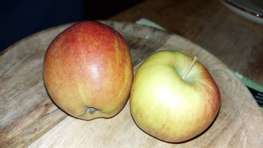 Ahşap servis tabağında elmalar. Organik meyve. Hasattan sonra çiğ elma. Meyveler vitamin ve minerallerle doludur. Doğal bir diş fırçası gibi. Tatlı ve ekşi olabilirler. Vejetaryen yemeği. Vejetaryen yemeği.