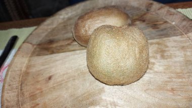 Tahta servis tabağında kivi. Organik meyve. Hasattan sonra çiğ kivi. Meyveler C vitaminleriyle doludur. Doğal ve eşsiz bir tadı var. Tatlı ve ekşi. Vejetaryen yiyecekler. Vejetaryen yemeği.