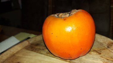 Tahta servis tabağında hurma meyvesi. Organik meyve. Hasattan sonra çiğ hurma. Meyveler vitamin doludur. Malların doğal bir meyvesi. Olgun ve tatlılar. Vejetaryen yiyecekler. Vejetaryen yemeği.