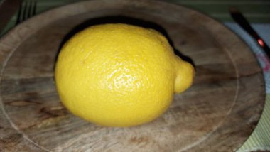 Tahta servis tabağında limon. Organik meyve. Hasattan sonra çiğ limon. Meyveler vitamin ve minerallerle doludur. Doğal bir güzellik iksiridir. Ekşiler. Vejetaryen yemeği. Vejetaryen yemeği.