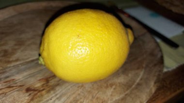 Tahta servis tabağında limon. Organik meyve. Hasattan sonra çiğ limon. Meyveler vitamin ve minerallerle doludur. Doğal bir güzellik iksiridir. Ekşiler. Vejetaryen yemeği. Vejetaryen yemeği.