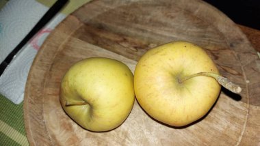 Ahşap servis tabağında elmalar. Organik meyve. Hasattan sonra çiğ elma. Meyveler vitamin ve minerallerle doludur. Doğal bir diş fırçası gibi. Tatlı ve ekşi olabilirler. Vejetaryen yemeği. Vejetaryen yemeği.