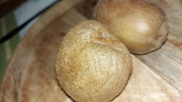 Tahta servis tabağında kivi. Organik meyve. Hasattan sonra çiğ kivi. Meyveler C vitaminleriyle doludur. Doğal ve eşsiz bir tadı var. Tatlı ve ekşi. Vejetaryen yiyecekler. Vejetaryen yemeği.