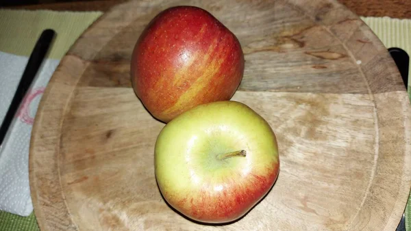 Ahşap servis tabağında elmalar. Organik meyve. Hasattan sonra çiğ elma. Meyveler vitamin ve minerallerle doludur. Doğal bir diş fırçası gibi. Tatlı ve ekşi olabilirler. Vejetaryen yemeği. Vejetaryen yemeği.