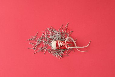 Çivili yatakta yatan spor ayakkabılar. Çivi adasında spor ayakkabılar.