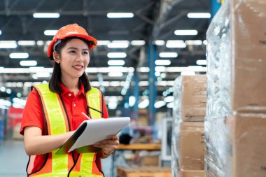 Kadın endüstriyel işçiler büyük bir endüstriyel fabrikada çalışıp kontrol ediyorlar..