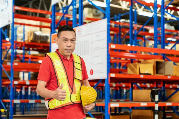 senior shipping company worker giving thumb up inside warehouse