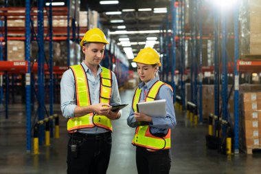 Male and Female Supervisors Holding Digital Tablet Talk about Inventory Check and Product Delivery in Retail Warehouse full of Shelves with Goods. Workers in Logistics Center. 