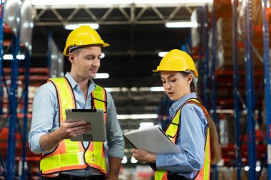 Male and Female Supervisors Holding Digital Tablet Talk about Inventory Check and Product Delivery in Retail Warehouse full of Shelves with Goods. Workers in Logistics Center. Portrait Shot