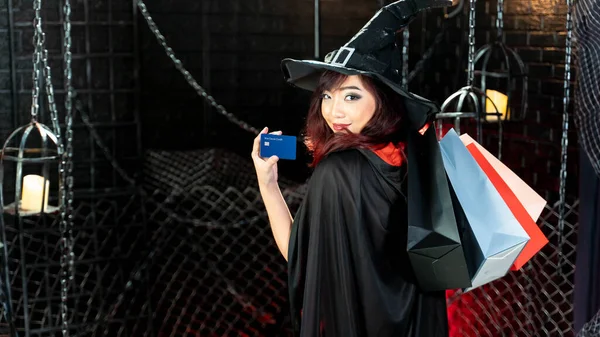 Vacker Ung Kvinna Häxa Kostym Visar Kreditkort Innehav Shoppingväskor Halloween — Stockfoto