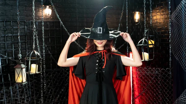 ハッピーゴシック若いです女性で魔女ハロウィン衣装で帽子立ってと笑顔でハロウィンテーマ — ストック写真