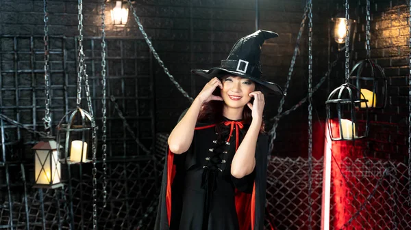 Happy halloween day. Young Asian beautiful woman model dressed as a witch costume smiling in haloween theme.