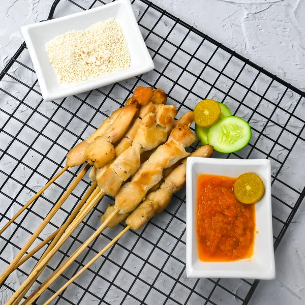 Sate Taichan, Grilled Chicken Satay without peanut sauce or soy sauce. Served on plate with sambal (chilli sauce). Selected focus.