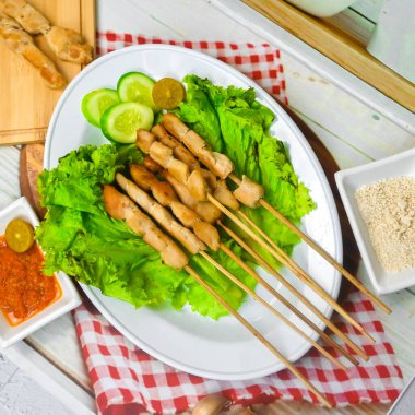 Sate Taichan, kızarmış tavuk, fıstık sosu ve soya sosu olmadan. Tabakta sambal (acı sos) ile servis edilir. Seçili odak.