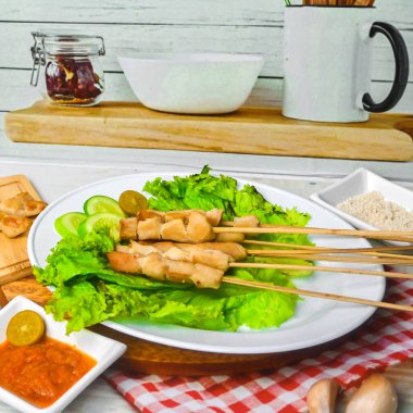 Sate Taichan, kızarmış tavuk, fıstık sosu ve soya sosu olmadan. Tabakta sambal (acı sos) ile servis edilir. Seçili odak.