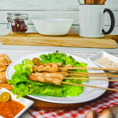 Sate Taichan, kızarmış tavuk, fıstık sosu ve soya sosu olmadan. Tabakta sambal (acı sos) ile servis edilir. Seçili odak.