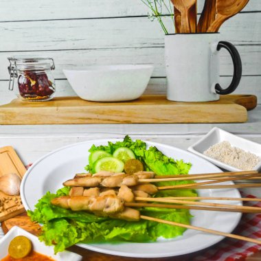 Sate Taichan, kızarmış tavuk, fıstık sosu ve soya sosu olmadan. Tabakta sambal (acı sos) ile servis edilir. Seçili odak.