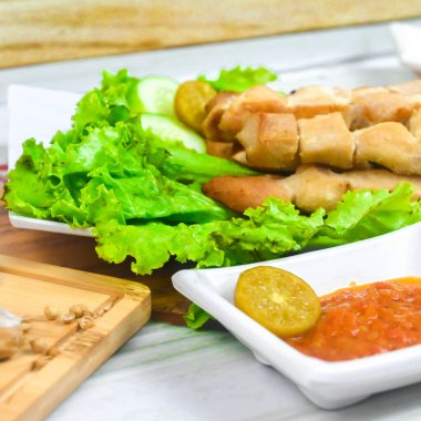 Sate Taichan, kızarmış tavuk, fıstık sosu ve soya sosu olmadan. Tabakta sambal (acı sos) ile servis edilir. Seçili odak.