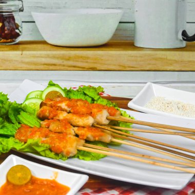 Sate Taichan, kızarmış tavuk, fıstık sosu ve soya sosu olmadan. Tabakta sambal (acı sos) ile servis edilir. Seçili odak.