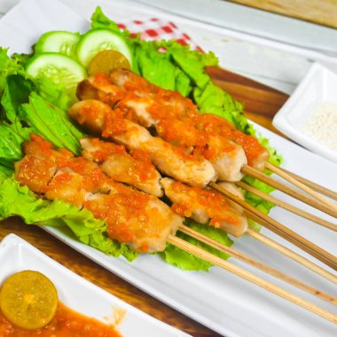 Sate Taichan, kızarmış tavuk, fıstık sosu ve soya sosu olmadan. Tabakta sambal (acı sos) ile servis edilir. Seçili odak.