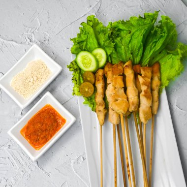 Sate Taichan, kızarmış tavuk, fıstık sosu ve soya sosu olmadan. Tabakta sambal (acı sos) ile servis edilir. Seçili odak.