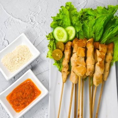 Sate Taichan, kızarmış tavuk, fıstık sosu ve soya sosu olmadan. Tabakta sambal (acı sos) ile servis edilir. Seçili odak.